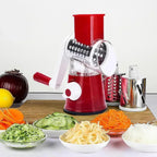 Manual vegetable rotary grater and slicer with bowls of shredded carrots, cucumbers, and cheese