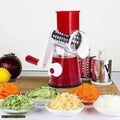 Multifunctional red rotary vegetable slicer and grater with sliced carrots, cucumbers and onions