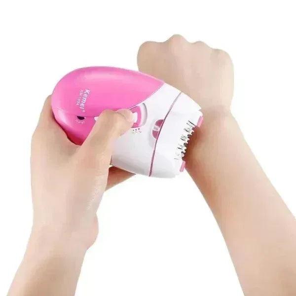 Person using a pink and white Kemei fabric shaver on their arm