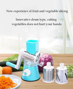 Blue rotary vegetable slicer with interchangeable drums and sliced carrots on a plate